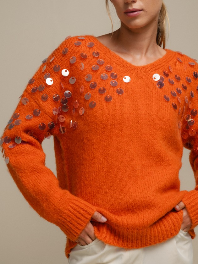 Knitted sweater with shiny applications