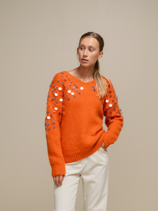 Knitted sweater with shiny applications