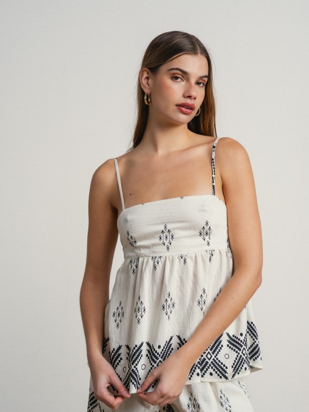 Printed tank top with thin straps and a slightly open back. Printed tank top with thin straps and a slightly open back.