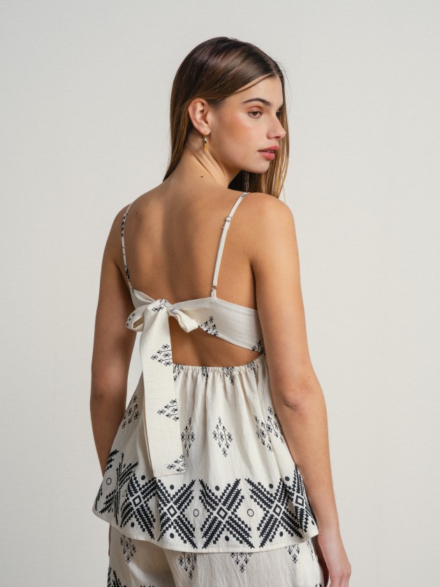 Printed tank top with thin straps and a slightly open back. Printed tank top with thin straps and a slightly open back.