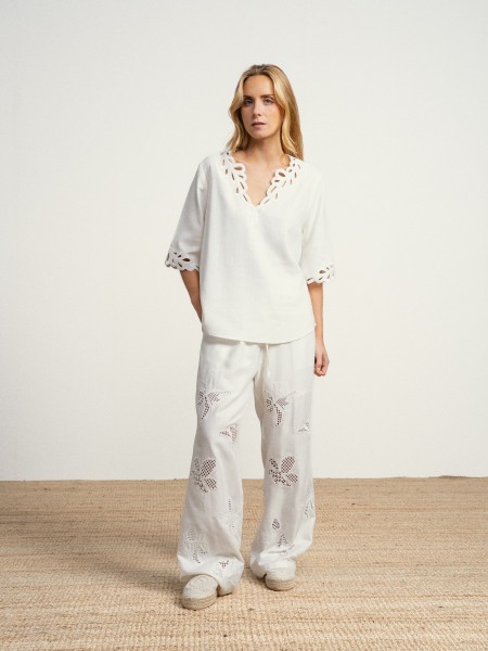 Wide-leg linen trousers with floral embroidery.