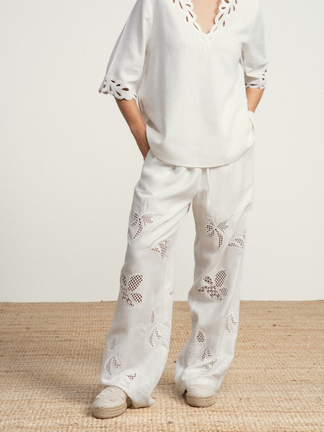 Wide-leg linen trousers with floral embroidery.