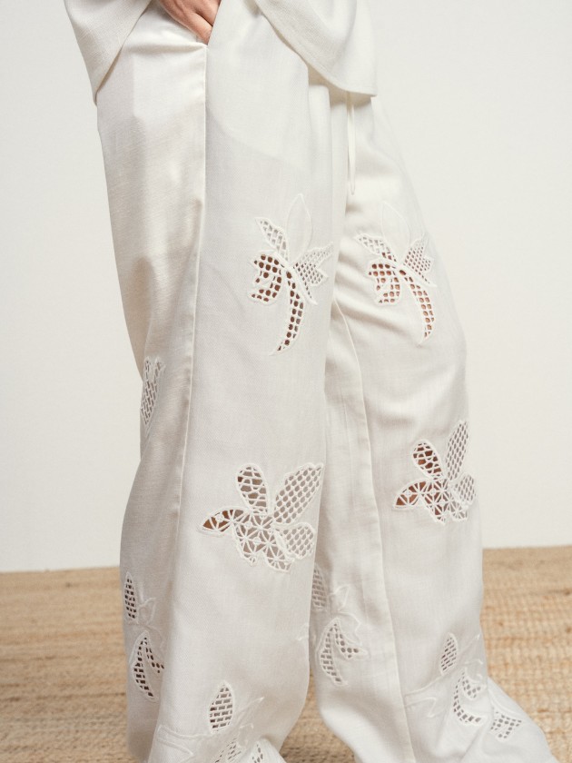 Wide-leg linen trousers with floral embroidery.