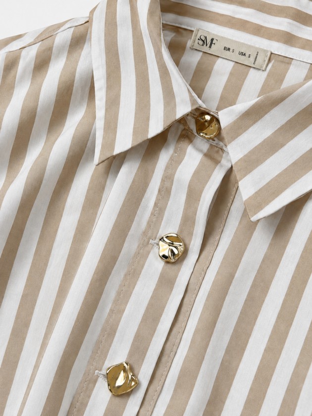 A shirt with rich, metallic buttons. A shirt with rich, metallic buttons.